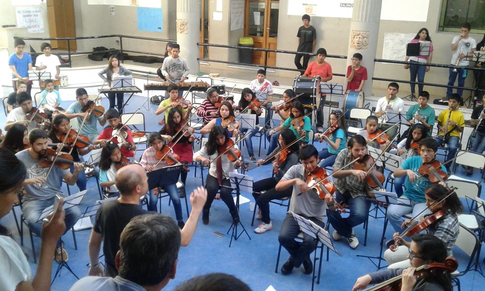 La imagen puede contener: 3 personas, personas en el escenario, personas sentadas y multitud